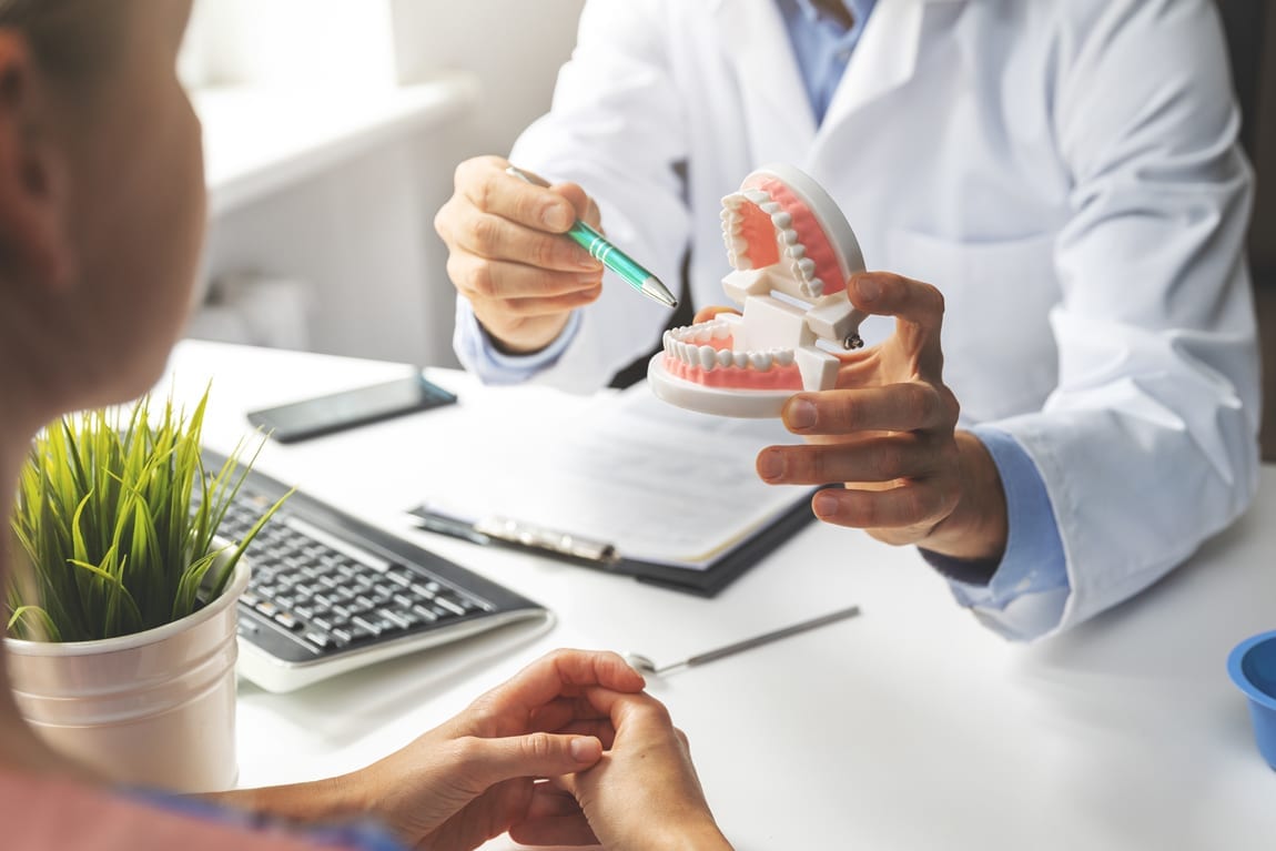 Dentist at West Richland Family Dental using model teeth to explain a concept