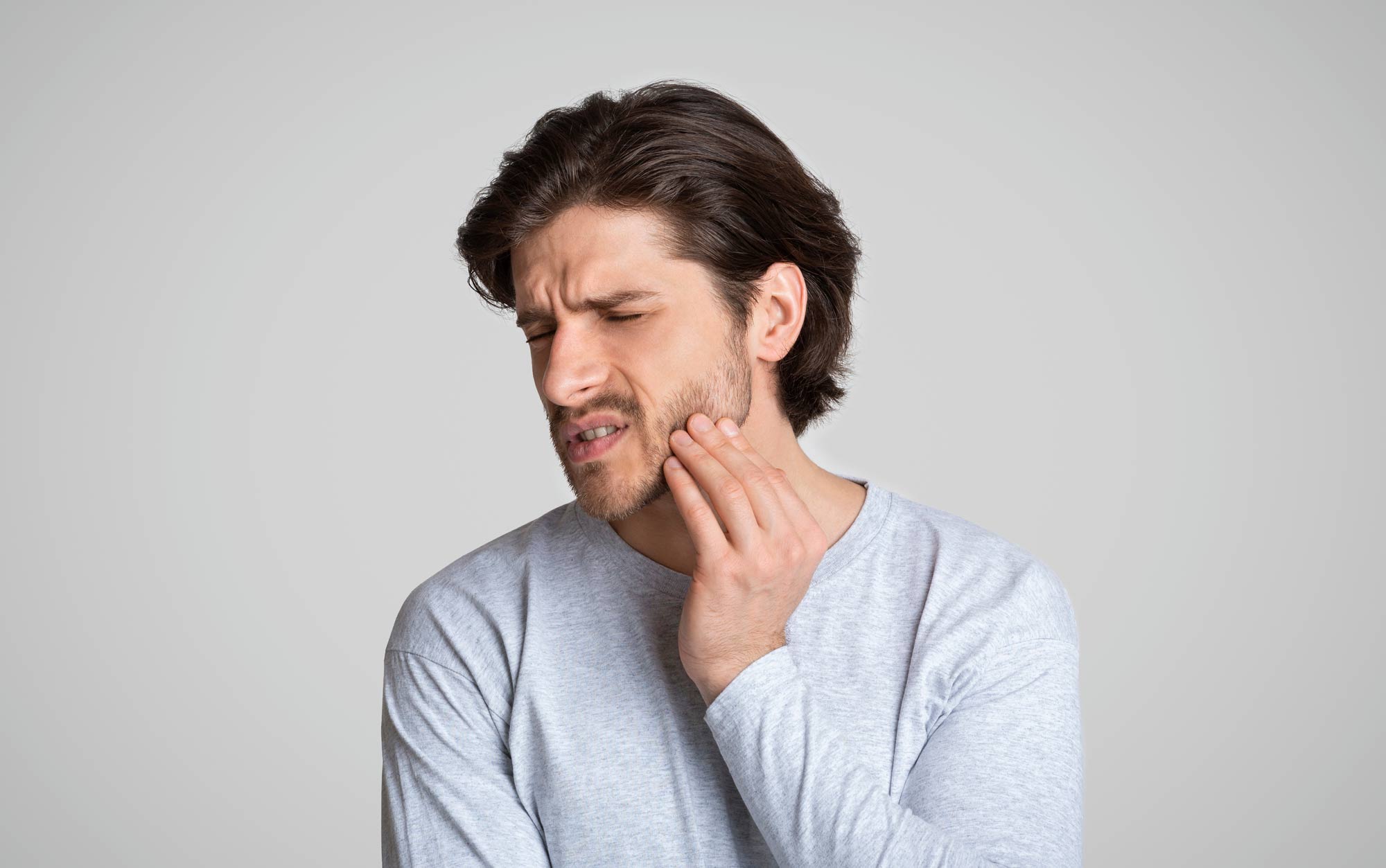 A male patient of West Richland Family Dental experiencing pain from a dental emergency prior to seeing the dentist for treatment.