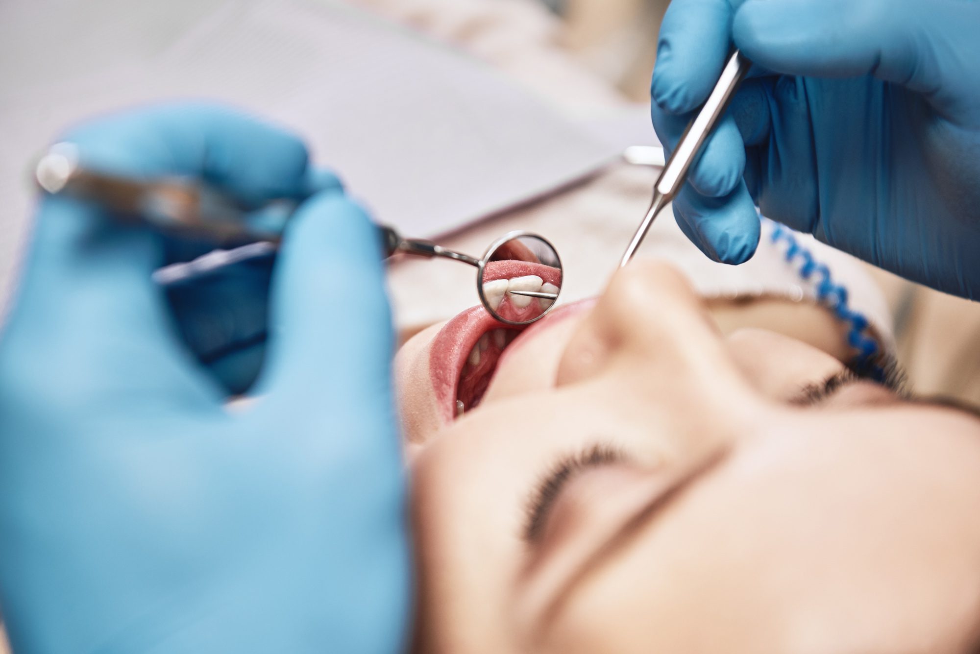 A female patient has an oral cancer screening as part of her 6-month dental visit at West Richland Family Dental