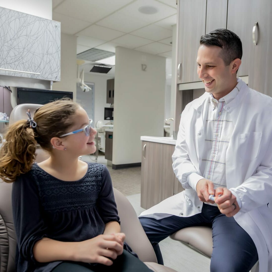 Dr. Karlson demonstrating a toothbrush at West Richland Family Dental for a female patient